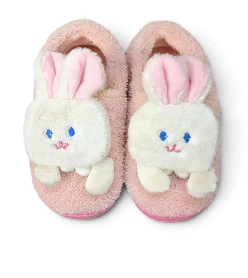 Children's pink bunny slippers on a fluffy carpet background